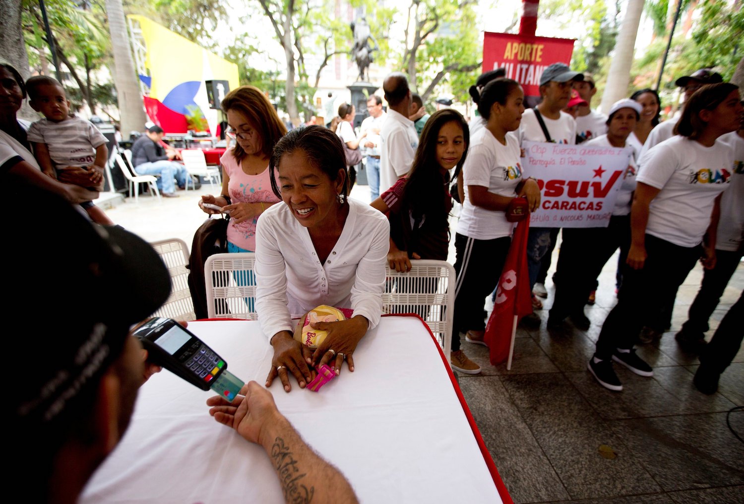 A member of the pro-government United Socialist Party of Venezuela, PSUV, donates to finance the Party, during a rally in Caracas, Venezuela, April 16, 2018. (AP/Fernando Llano)