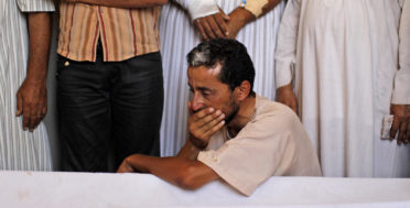 A relative of two children and their mother, who died after a NATO bomb fell on their home, grieves during their funeral in Zlitan, Libya, Aug. 4, 2011. (AP/Dario Lopez-Mills)