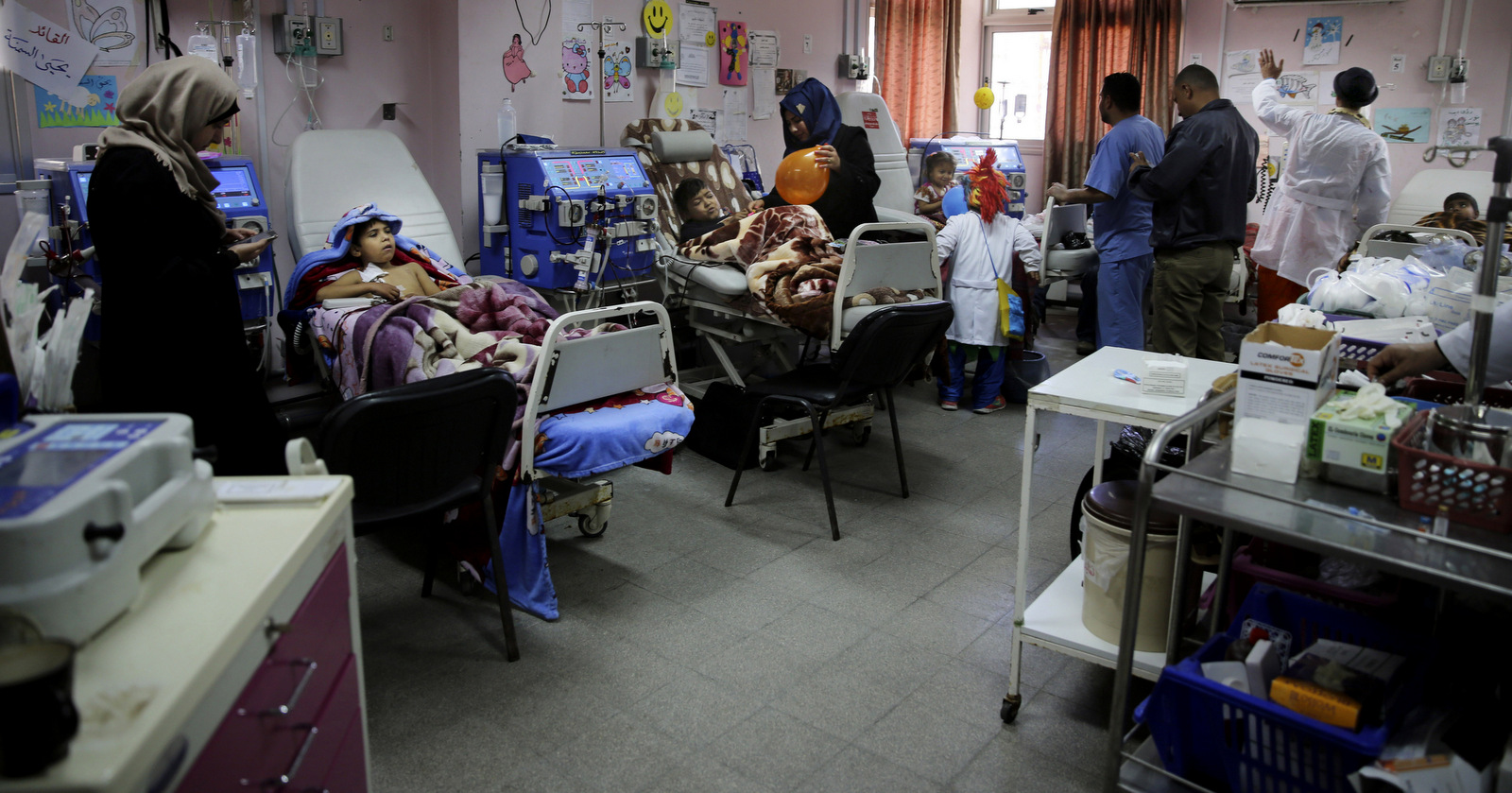 In this Thursday, March 17, 2016 photo, Palestinian clown doctors entertain children in the department of kidney diseases at Al-Rantisi children’s hospital in Gaza City. Clown doctors Majed Kaloub, 24, and Alaa Miqdad, a 33-year-old dwarf, are employed by an international NGO into unusual places: hospitals, especially the pediatric ones; a game-changing shift that granted them steady work at best, but rendered them in need for psychosocial support as a side effect of the job. (AP Photo/Adel Hana)