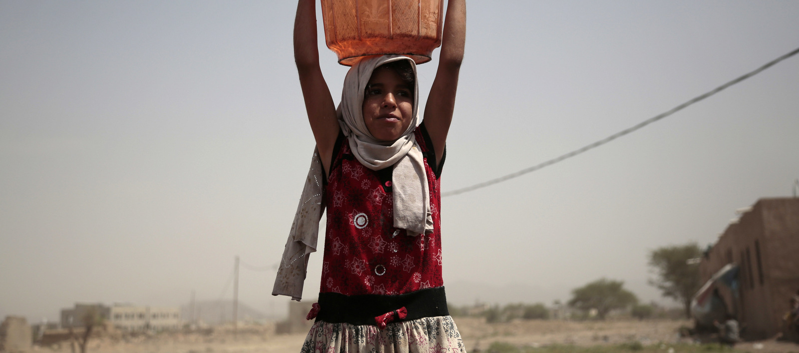 A girl carries a bucket filled with water from a well that is allegedly contaminated with cholera bacteria, on the outskirts of Sanaa, Yemen, Wednesday, July 12, 2017. The U.N. health agency said Tuesday that plans to ship cholera vaccine to Yemen are likely to be shelved over security, access and logistical challenges in the war-torn country. Yemen's suspected cholera caseload has surged past 313,000, causing over 1,700 deaths in the world's largest outbreak. (AP Photo/Hani Mohammed)
