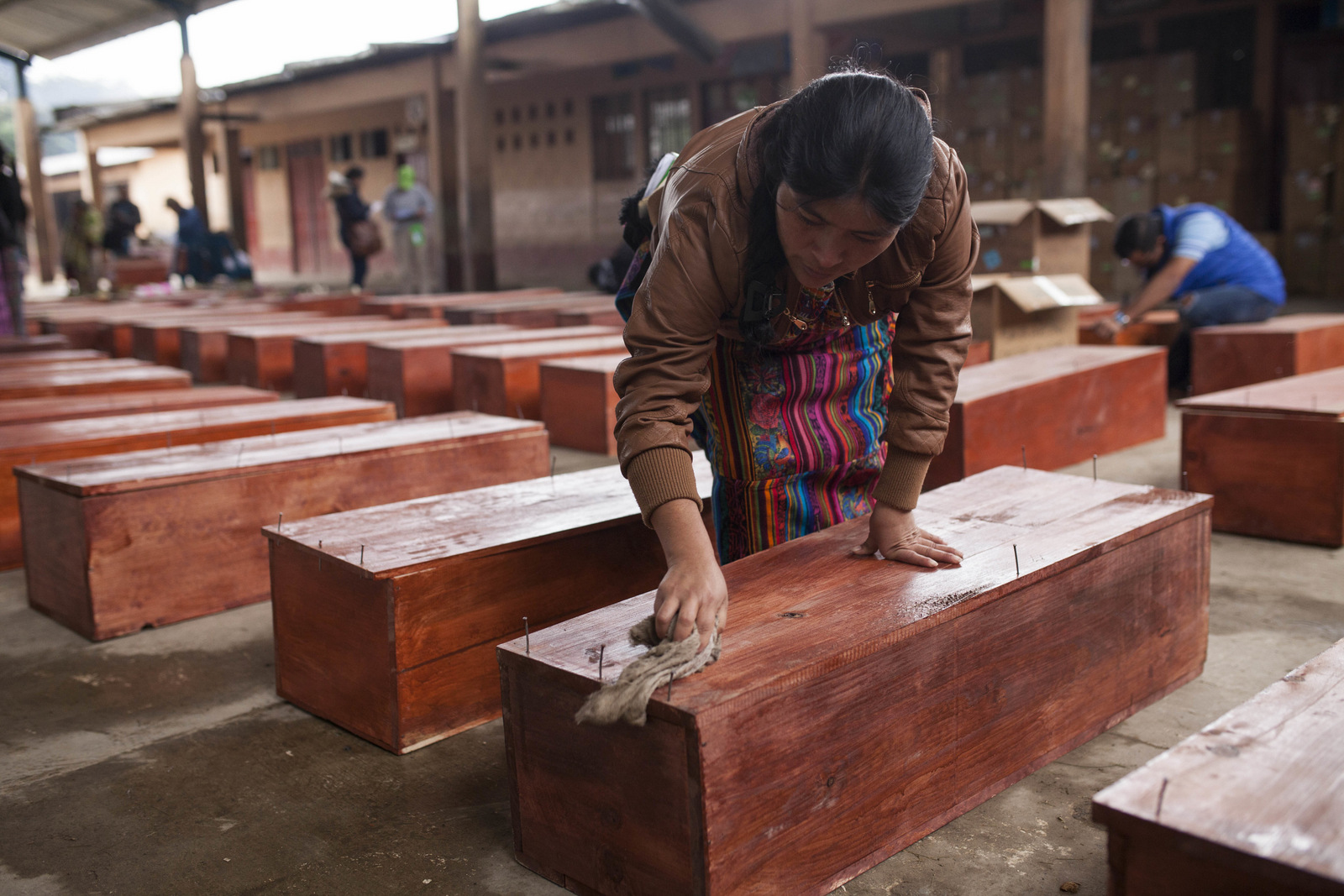 An Ixil Mayan woman cleans a coffin holding the remains of a civil war victim prior to a mass burial in Santa Avelina, Guatemala, Nov. 30, 2017. After seven years of work by forensic anthropologists, including DNA tests to locate relatives, the remains of 172 indigenous Ixil Mayans killed during the civil war between 1978 and 1982 were buried in the western mountains of Guatemala. (AP/Moises Castillo)