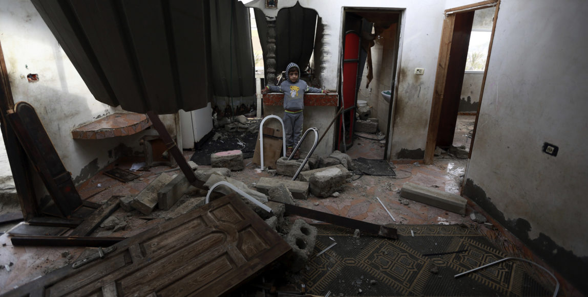 A Palestinian boy stands inside a damaged home following early morning Israeli airstrikes in town of Khan Younis, southern Gaza Strip, Wednesday, Dec. 13, 2017. The Israeli military says it has carried out airstrikes in Gaza is response to rocket fire toward southern Israel. The military says it struck a Hamas military compound in southern Gaza early on Wednesday. No casualties were reported. (AP Photo/Khalil Hamra)