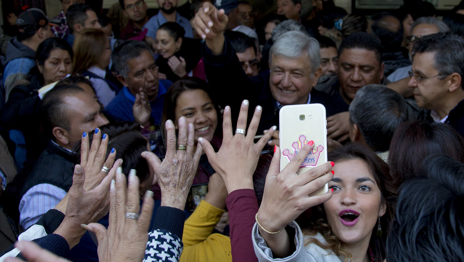 A woman takes a selfie backdropped with presidential hopeful Andres Manuel Lopez Obrador during a pre-campaign rally in Mexico City, Dec. 15, 2017. (AP/Eduardo Verdugo)