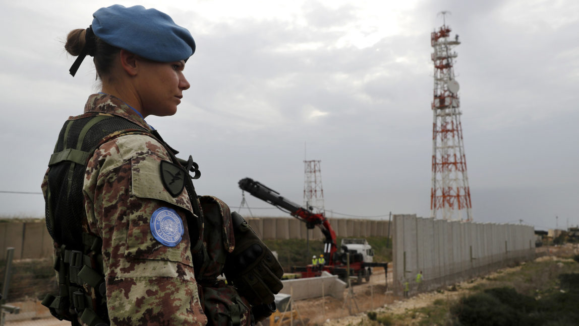 A U.N. peacekeeper observes construction workers building a wall along the Israeli border with Lebanon, in the costal town of Naqoura, south Lebanon, Feb. 8, 2018. (AP/Hussein Malla)