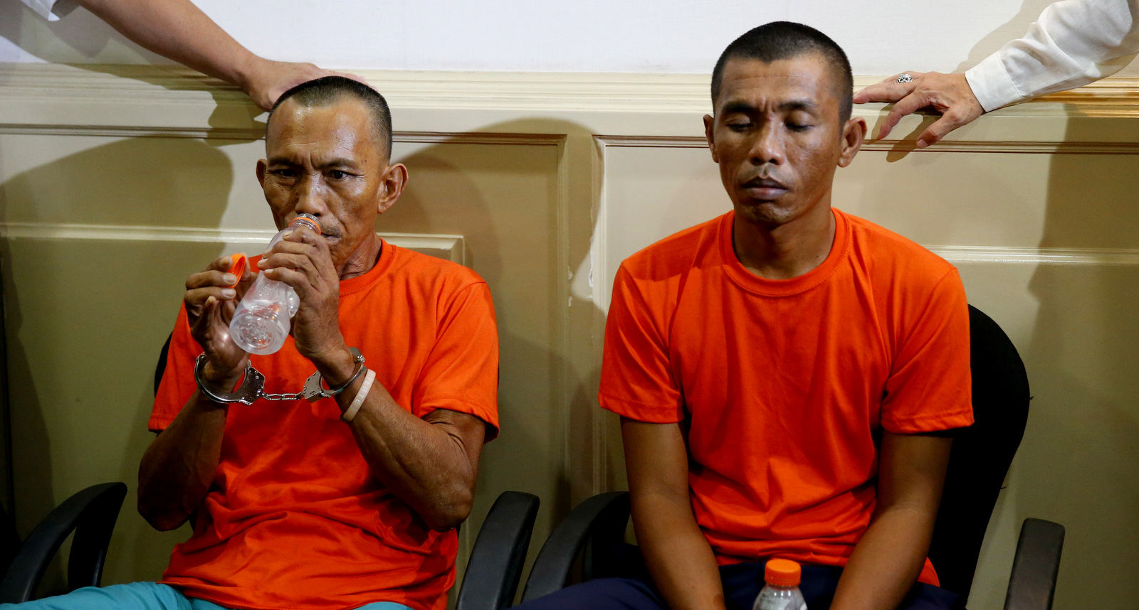 Two suspected Abu Sayyaf militants Hood Abduallah, left, and Jimmy Bla wait to be presented to the media by Justice Secretary Vitaliano Aguirre in a news conference at the National Bureau of Investigation headquarters Monday, March 12, 2018 in Manila, Philippines. In the Justice Department press statement, the two were arrested two weeks ago in Zamboanga, southern Philippines and allegedly were involved in kidnappings in 2001 and 2002 including that of American missionaries Martin and Gracia Burnham. (AP Photo/Bullit Marquez)
