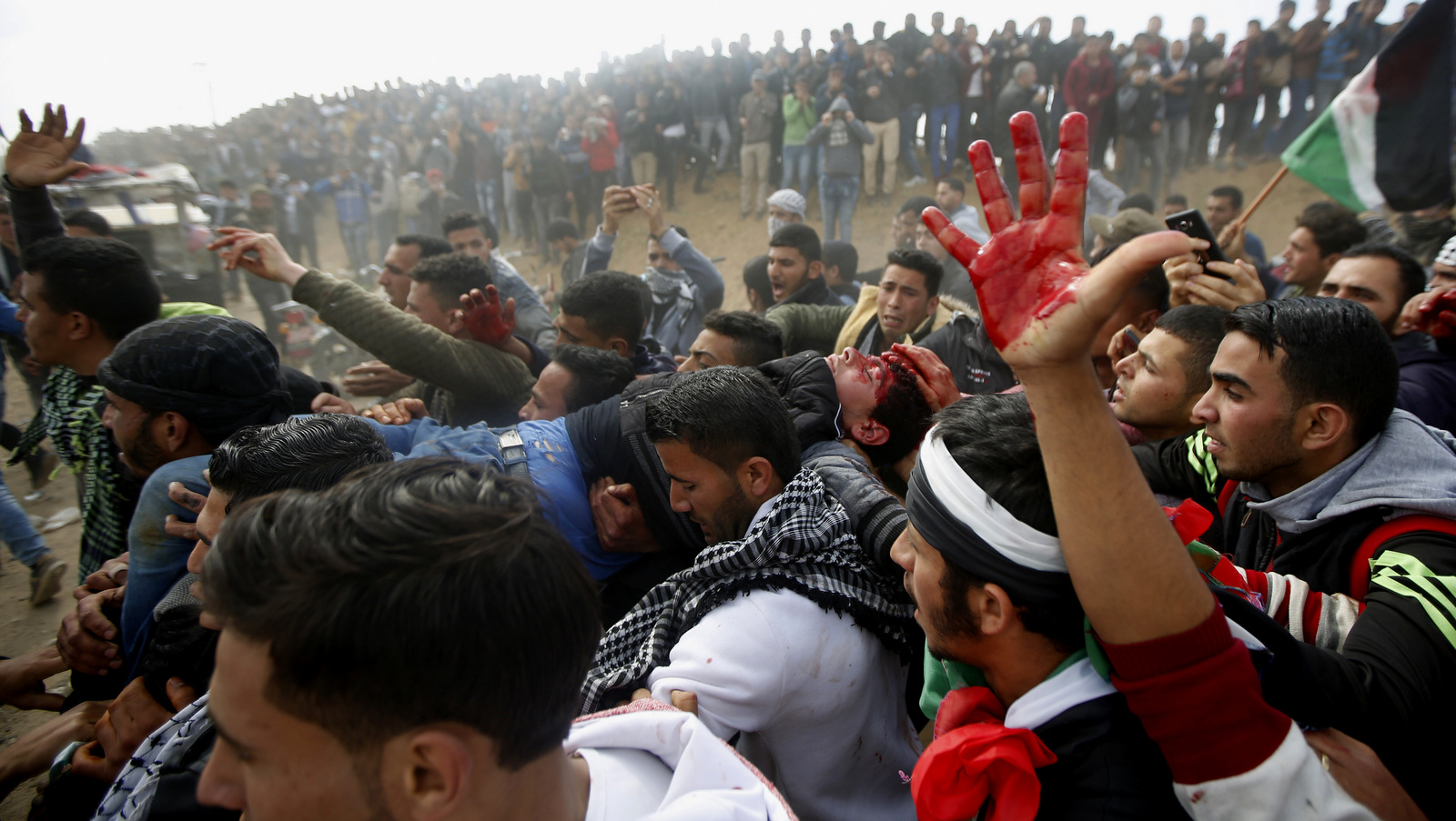 Palestinian protesters evacuate a wounded youth during clashes with Israeli troops along the Gaza Strip border with Israel, east of Khan Younis, Gaza Strip, Friday, March 30, 2018. (AP Photo/Adel Hana)