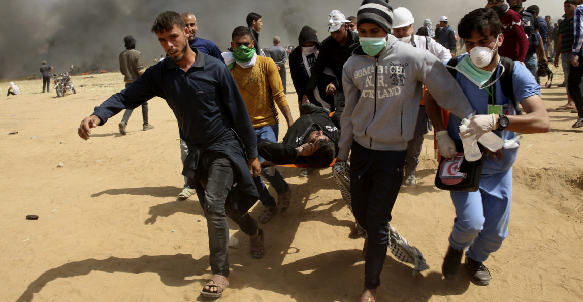 Palestinian protesters evacuate a wounded youth during clashes with Israeli troops along Gaza's border with Israel, Friday, April 6, 2018. (AP/Adel Hana)