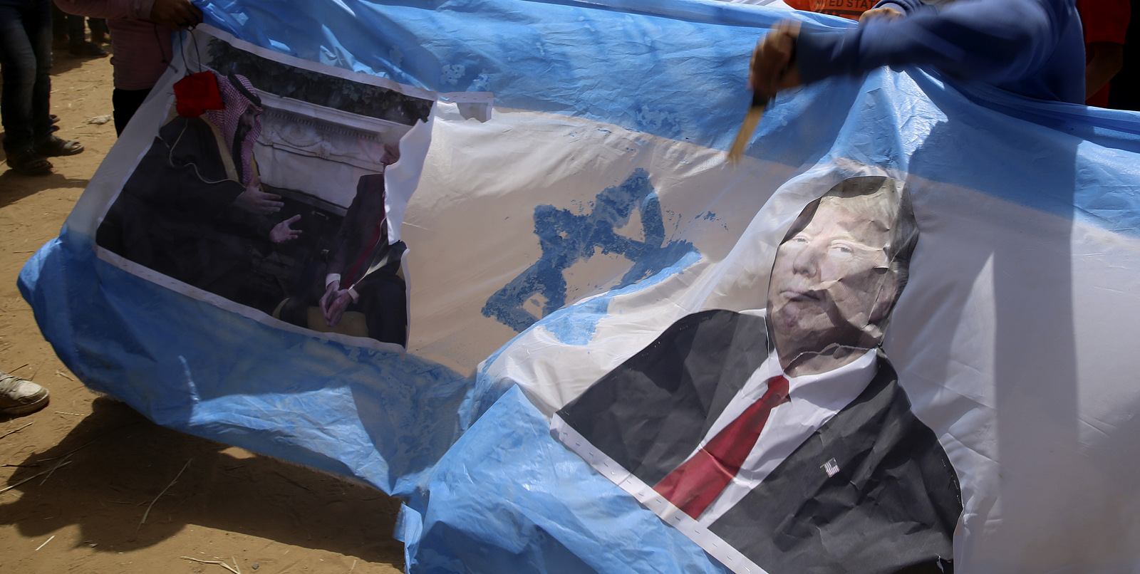 Palestinian protesters beat a representation of an Israeli flag with pictures of U.S. President Donald Trump and Saudi crown prince Mohammed bin Salman during clashes with Israeli troops along Gaza's border with Israel, April 13, 2018. Thousands of Palestinians staged a mass protest along Gaza's sealed border with Israel, some burning Israeli flags, and Israeli soldiers fired tear gas and live bullets from across the border fence. (AP/Adel Hana)