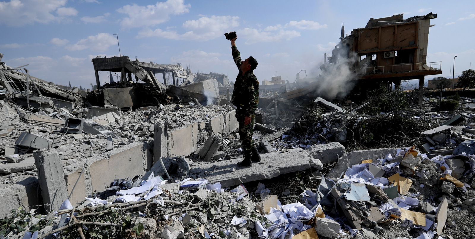 A Syrian soldier films the damage of the Syrian Scientific Research Center in Barzeh which was attacked by U.S., British and French military strikes to punish President Bashar Assad for an alleged chemical attack, near Damascus, Syria, April 14, 2018. (AP/Hassan Ammar)