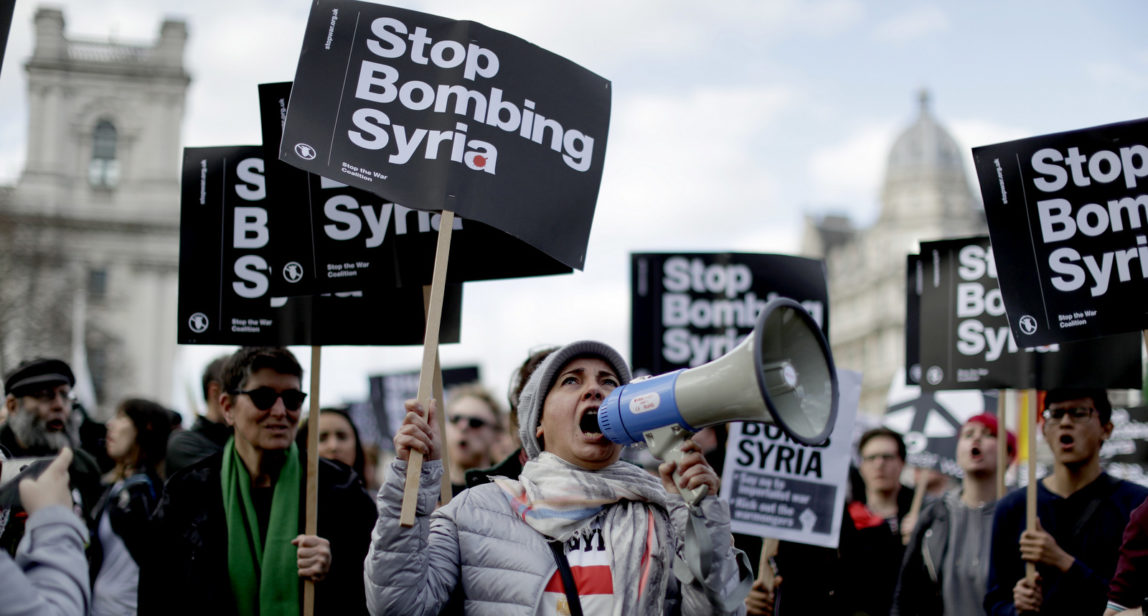 Demonstrators take part in a protest organized by the Stop the War coalition against the British government carrying out airstrikes on targets in Syria, in Parliament Square, London, Monday, April 16, 2018. British Prime Minister Theresa May faced restive lawmakers on Monday to justify her decision to launch airstrikes against Syria without a vote in Parliament. (AP Photo/Matt Dunham)