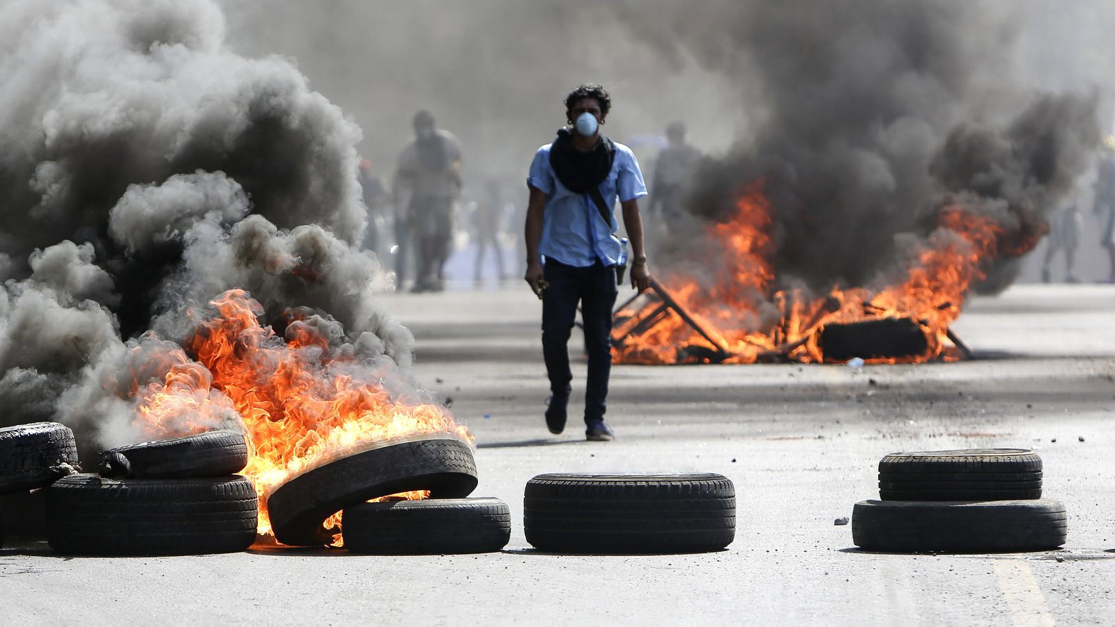 A protester walks between burning tires in Managua, Nicaragua, April 20, 2018. Clashes, between protesters opposed to social security reforms and police and pro-government groups, rocked the capital, and a half-dozen other cities over the last three days. (AP/Alfredo Zuniga)