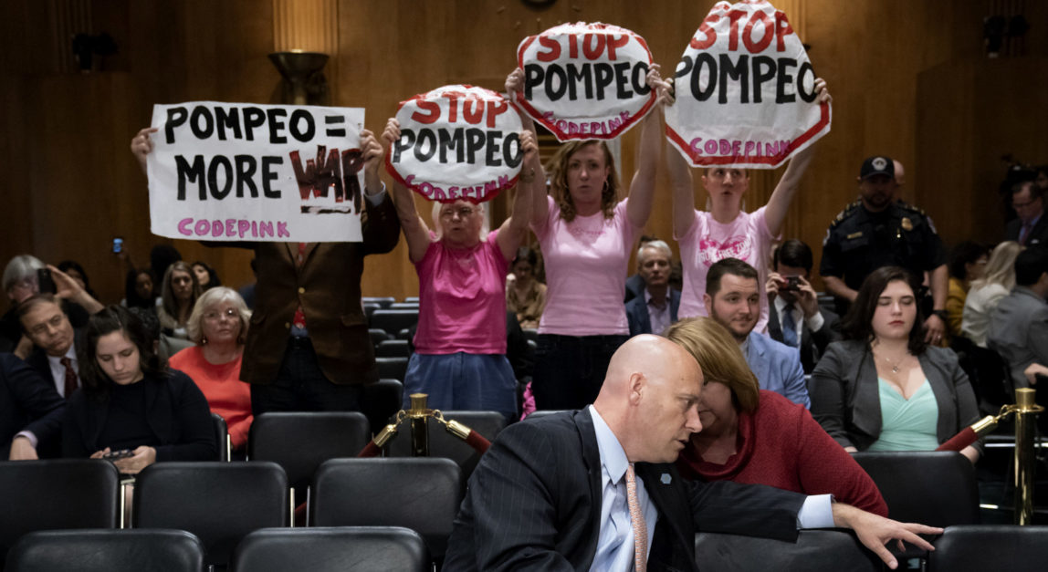 Protesters disrupt a confirmation vote on President Donald Trump's nominee for secretary of state, Mike Pompeo, who has faced considerable opposition before the panel, as Marc Short, center, the White House legislative liaison, sits in the audience, on Capitol Hill in Washington, April 23, 2018. (AP/J. Scott Applewhite)
