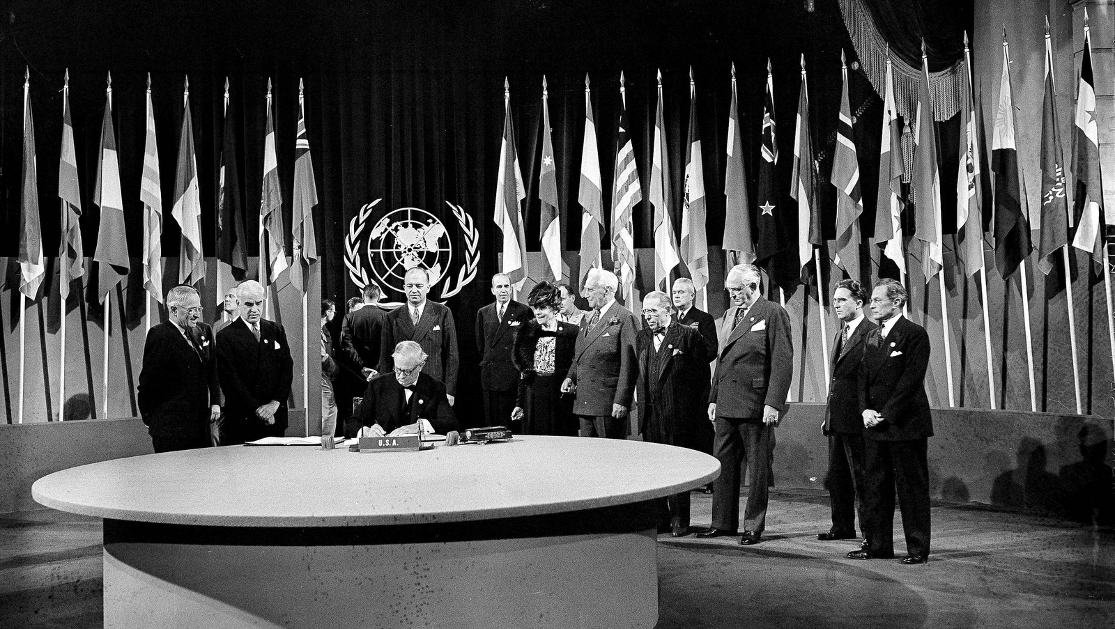 President Harry S. Truman and the entire American delegation look on as Sen. Tom Connally signs the United Nations Charter in San Francisco, June 26, 1945. Standing, from left: President Truman; Secretary of State Edward Stettinius Jr.; Harold Edward Stassen; unidentified; Dean Virginia Gildersleeve; Rep. Charles A. Eaton; Rep. Sol Bloom, and Sen. Arthur Vandenberg. (AP Photo)