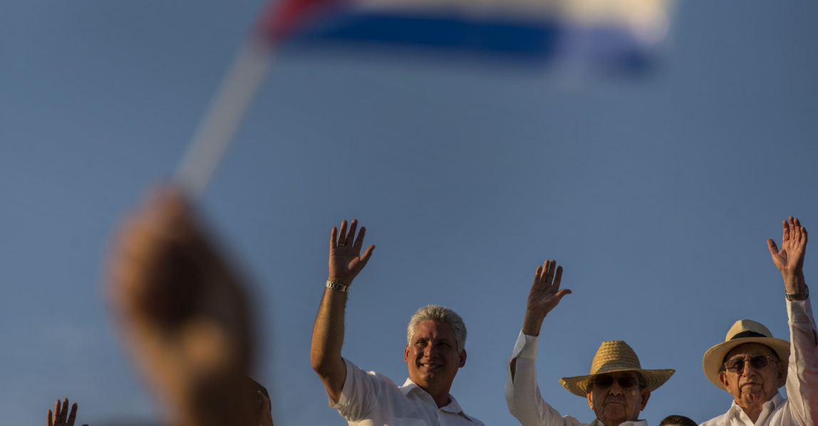 Cuba's Vice President Miguel Diaz-Canel, left, Cuba's President Raul Castro, center, and Cuba's Vice President Jose Ramon Machado Ventura, wave as they watch the May Day parade at Revolution Square, in Havana, Cuba, Sunday, May 1, 2016. Thousands of people converged on the square for the traditional May Day march. (AP Photo/Ramon Espinosa)