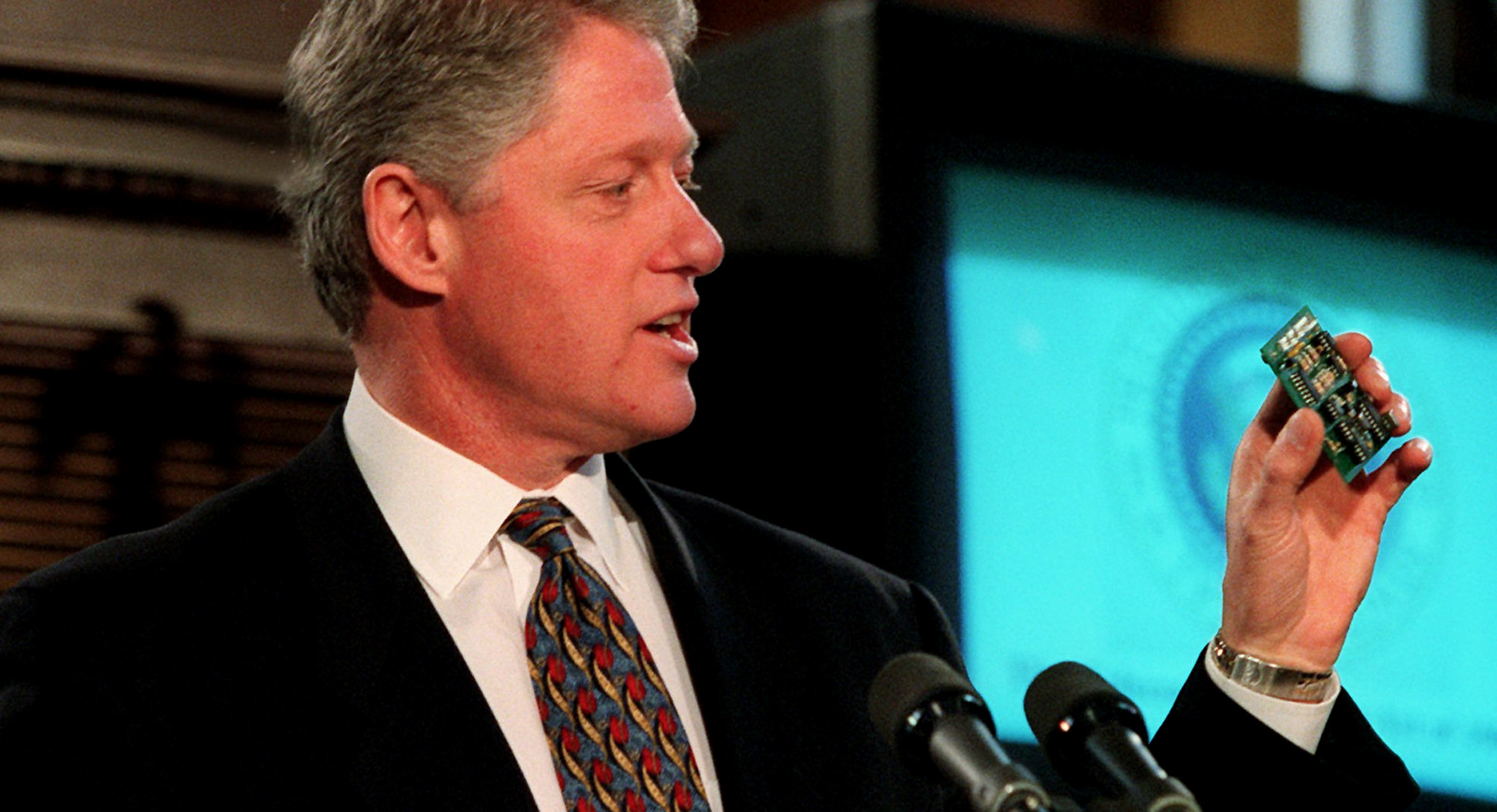 President Clinton holds a V-chip at the Library of Congress in Washington Thursday Feb. 8, 1996 where he signed the Telecommunications Reform Act. The chip gives parents a powerful tool to zap from their television sets shows electronically rated for violent and other objectionable content. (AP Photo/Doug Mills)