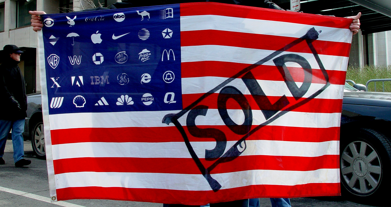 Protester holding Adbuster's Corporate American Flag at Bush's 2nd inauguration, Washington DC.