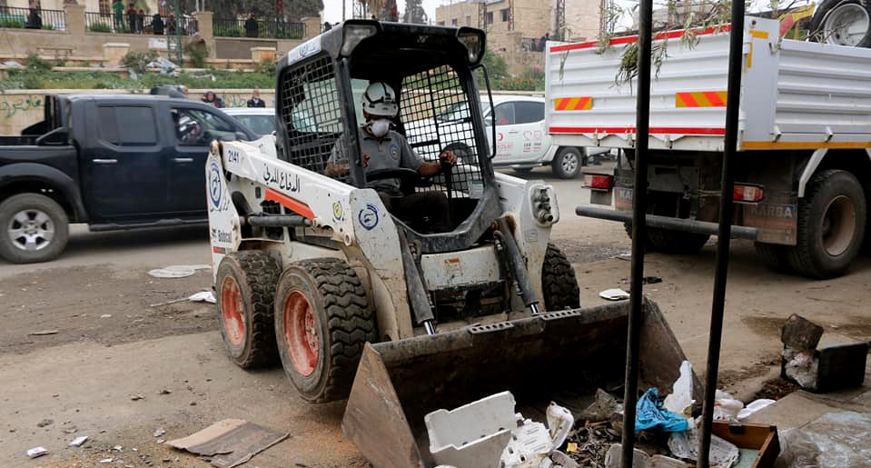 A member of the White Helmets works a skidsteer emblazoned with the White Helmets logo in the recent captured city of Afrin, Syria. (Photo: The White Helmets/Twitter)
