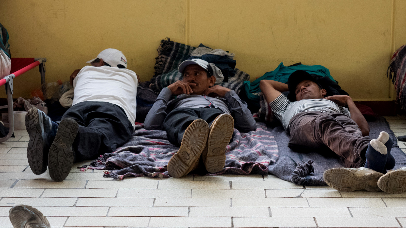 Three men rest after arriving to the Casa del Peregrino in Mexico City, April 10, 2018.