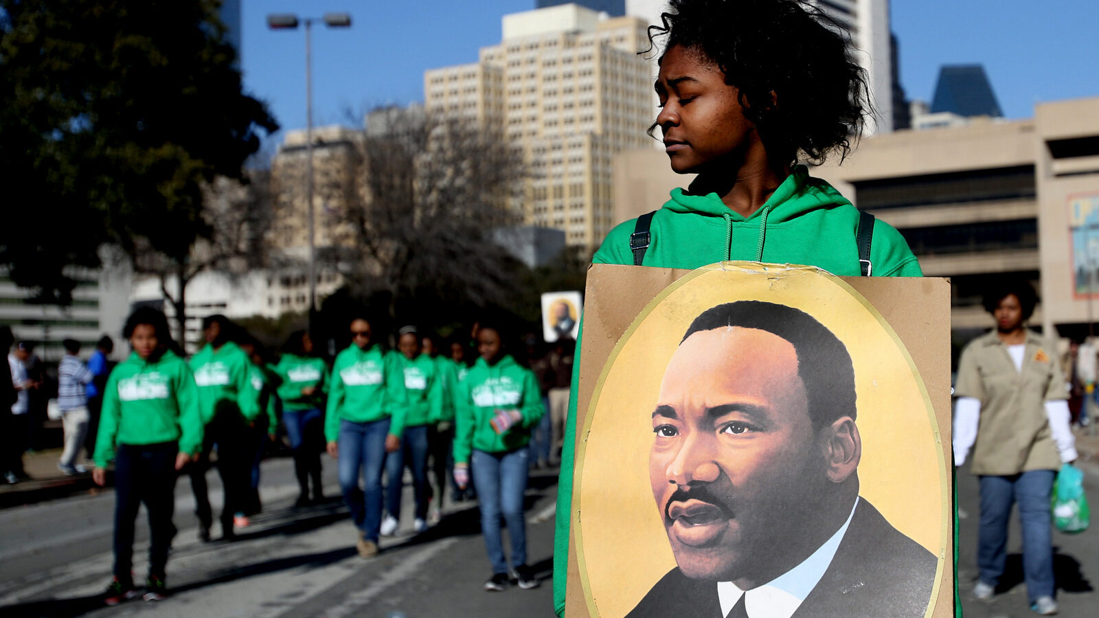 Sakidra Davis of Alpha Rho Xinos carries an image of Martin Luther King Jr. during the 32nd annual Martin Luther King Jr. Birthday Celebration's March/Parade on Saturday Jan. 18, 2014, in Dallas, Texas. (AP Photo/The Dallas Morning News, Sarah Hoffman)