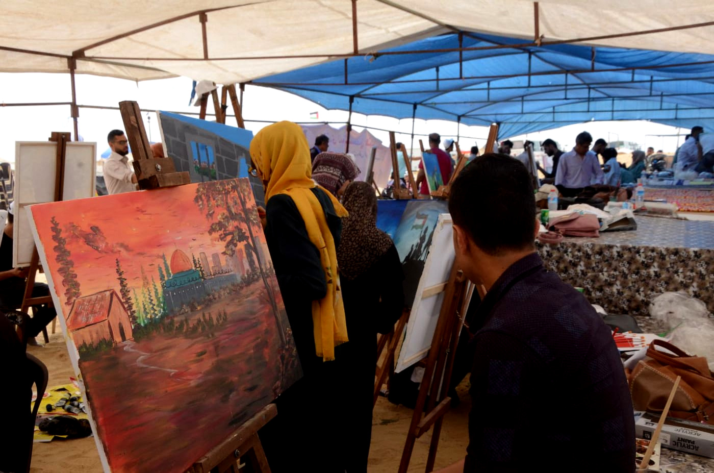 Artists work on original pieces in the art protest tent near the Great Return March protests on the Gaza border. (Photo: Karim Naser)