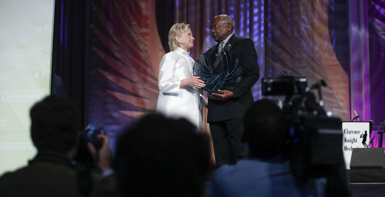 Democratic presidential candidate Hillary Clinton, left, accompanied by James Clyburn, D-S.C., right, receives the Phoenix award at the Congressional Black Caucus Foundation's Phoenix Awards Dinner at the Washington Convention center, in Washington, Saturday, Sept. 17, 2016. | AP