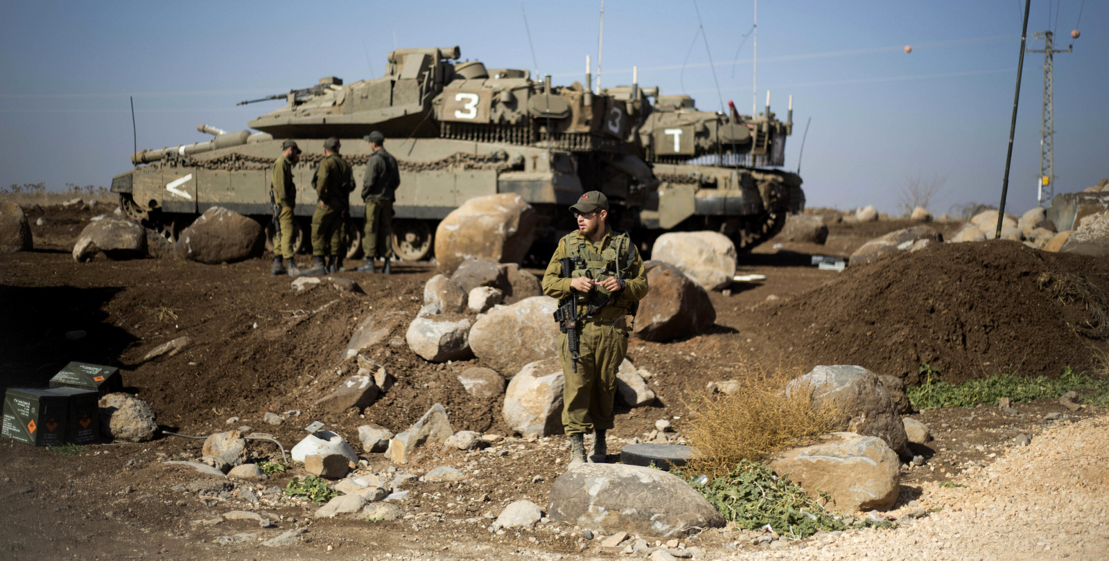 Israeli soldiers gather next to their tanks near the border with Syria in the Israeli-occupied Golan Heights. (AP Photo/Ariel Schalit)