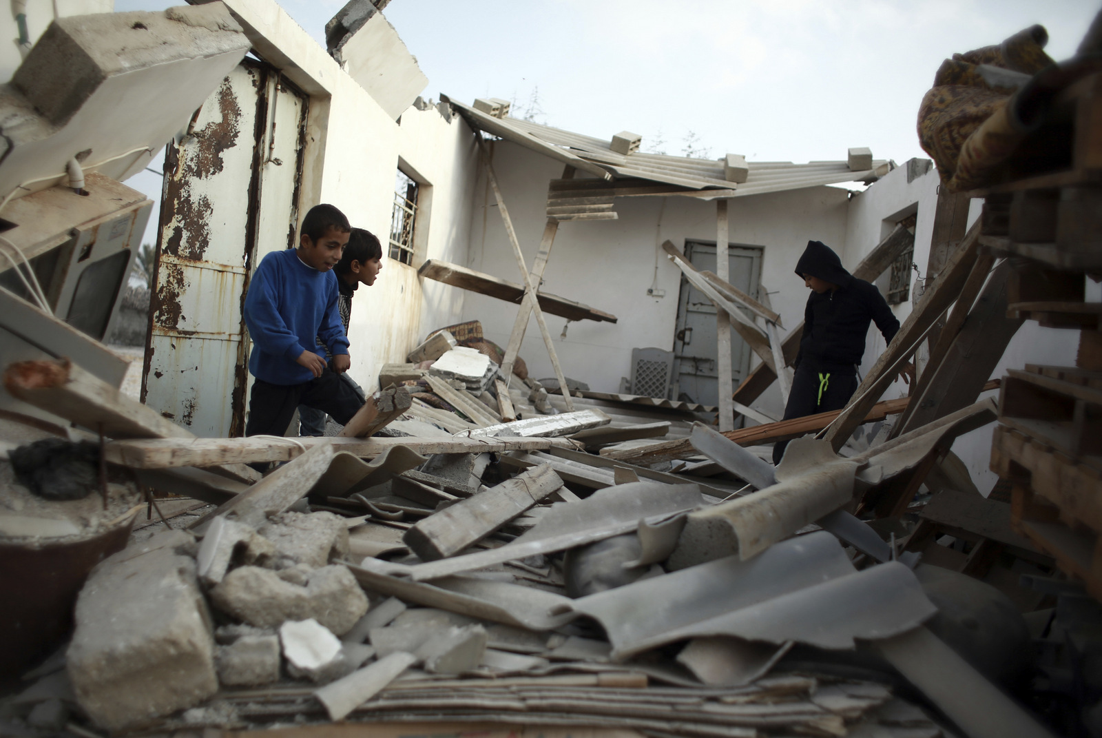 Niños palestinos revisan los restos de su hogar golpeado por un ataque aéreo israelí en la ciudad de Khan Younis, Gaza, el 13 de diciembre de 2017. Khalil Hamra | AP