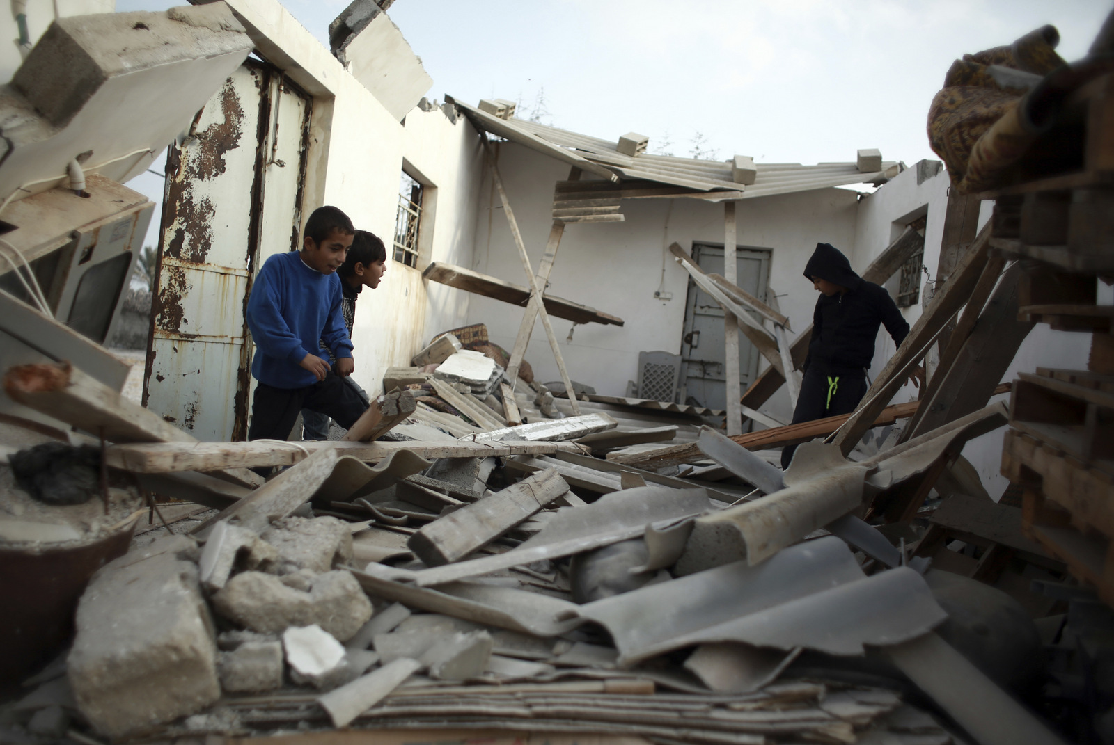 Palestinian children check survey the remnants of their home struck by an Israeli airstrike in town of Khan Younis, Gaza, Dec. 13, 2017. Khalil Hamra | AP