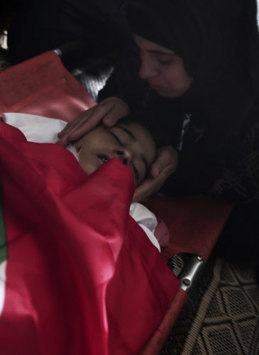 A relative reacts to the lifeless body 15-year old Palestinian boy, Azzam Hillal (Owidah), at his home during his funeral in Khan Younis, southern Gaza Strip, April 28, 2018. Hillal died a day after being shot in the head by an Israeli soldier. (AP/ Khalil Hamra)