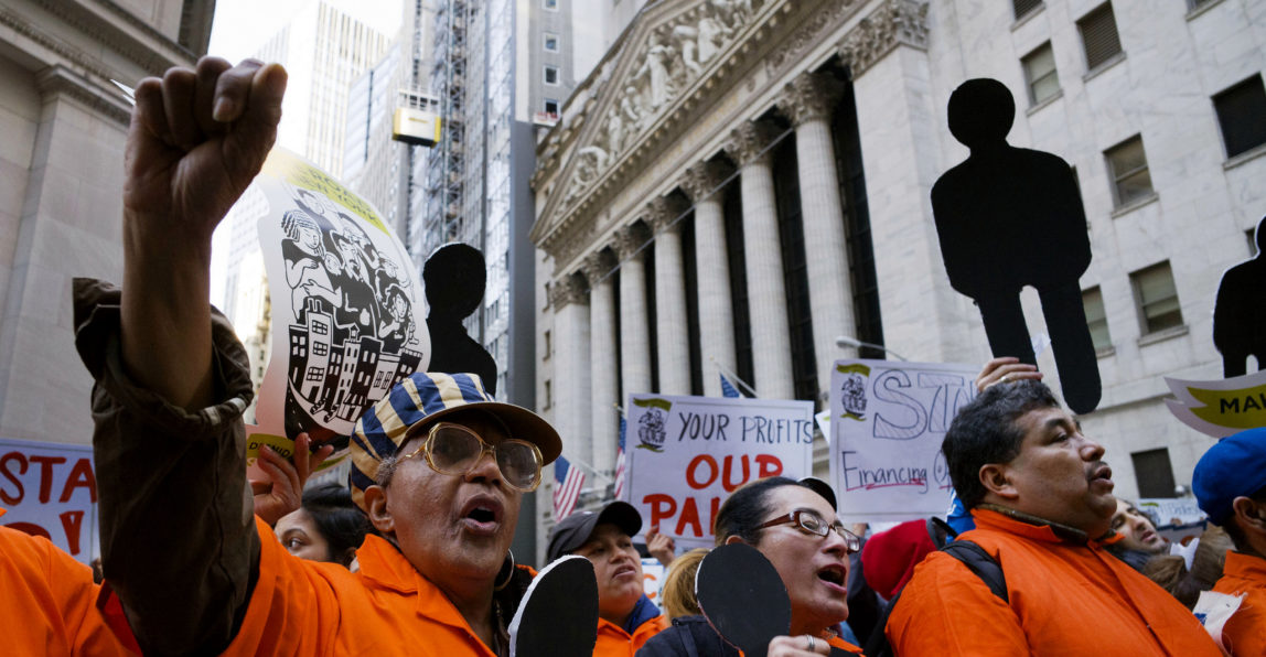 Protesters march on Wall Street in front of the New York Stock Exchange, Tuesday, May 1, 2018. Workers and activists marked May Day with rallies around the world to demand their government address labor issues. (AP/Mark Lennihan)