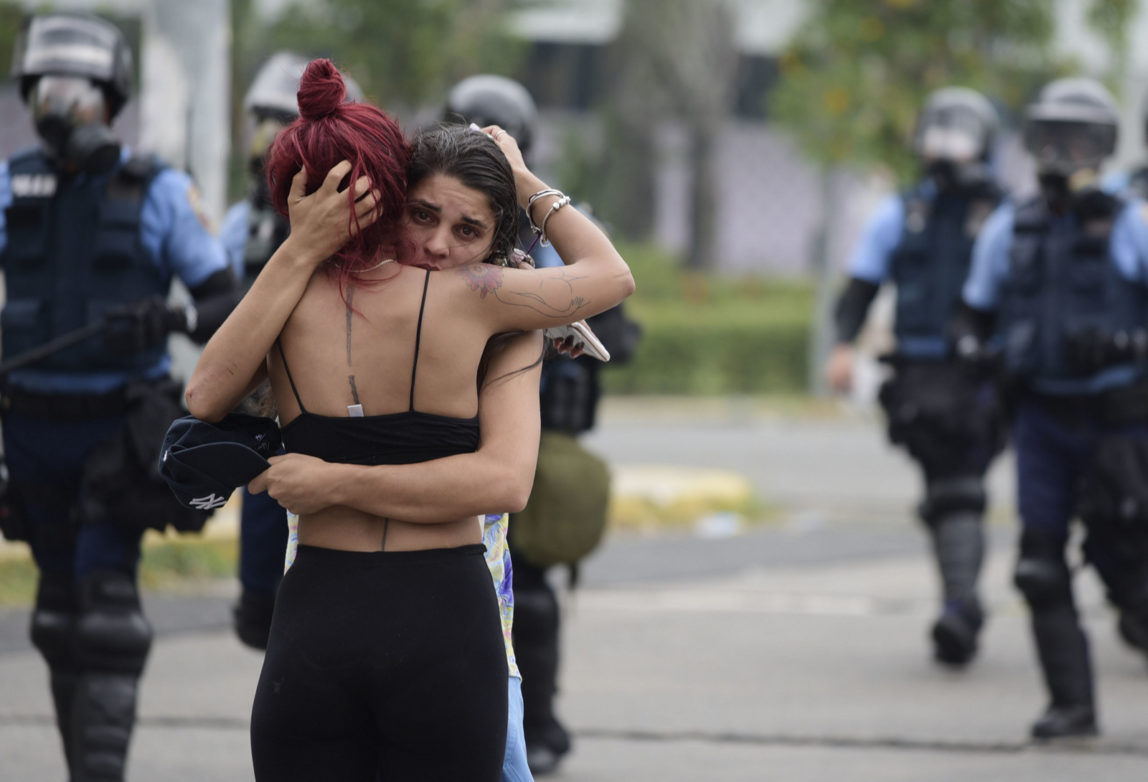 Two women embrace after a May Day march turned violent, in San Juan, Puerto Rico, May 1, 2018. (AP/Carlos Giusti)