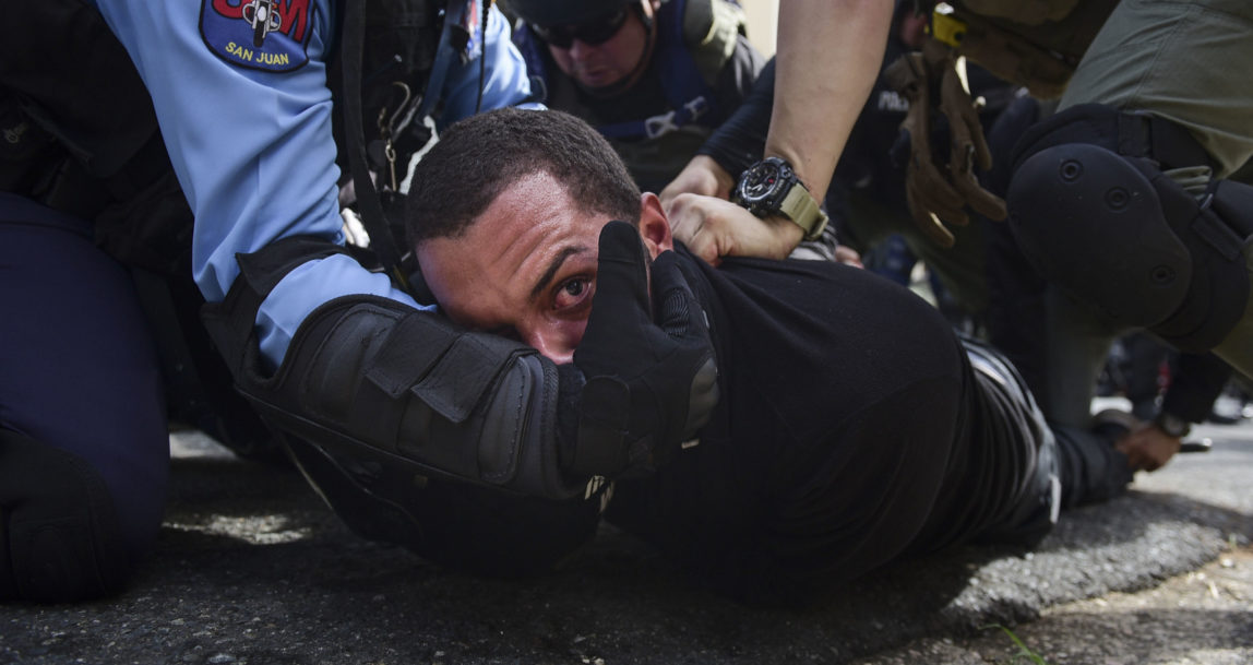 Police detain a protester after a May Day march to protest pension cuts, school closures and slow hurricane recovery efforts turned violent, in San Juan, Puerto Rico, May 1, 2018. (AP/Carlos Giusti)