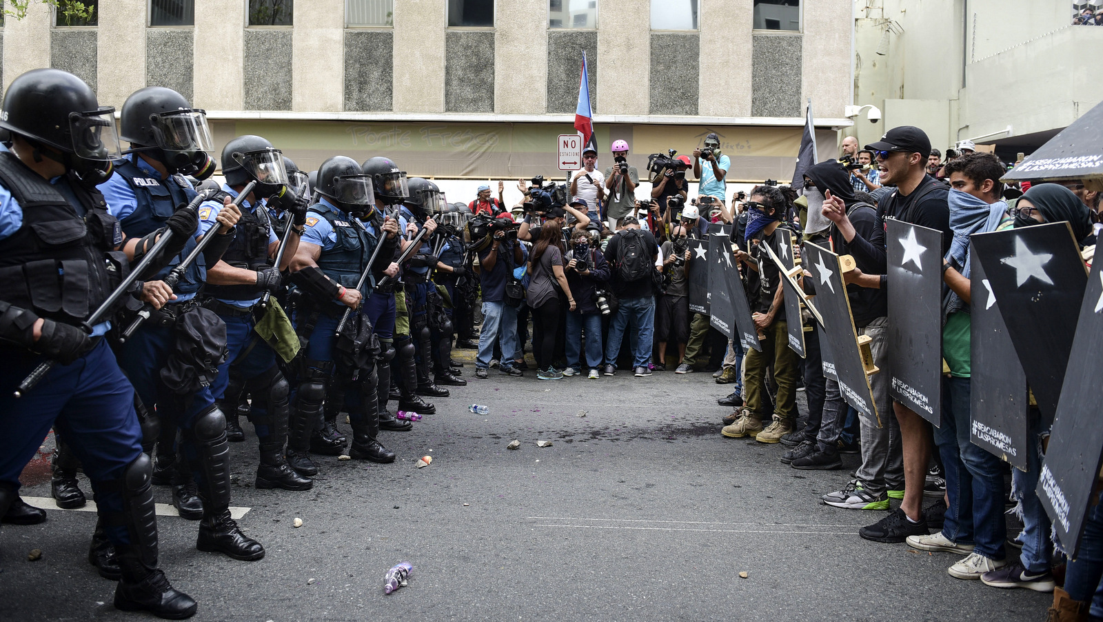 Police and protesters face off after a May Day march turned violent, in San Juan, Puerto Rico, May 1, 2018. Protesters clashed with police who fired tear gas and rubber bullets to disperse the crowd. (AP/Carlos Giusti)