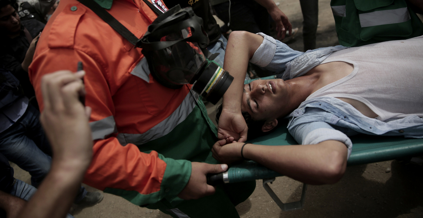 Palestinian medics evacuate a wounded youth during a protest at the Gaza Strip's border with Israel, Friday, May 4, 2018. (AP Photo/ Khalil Hamra)