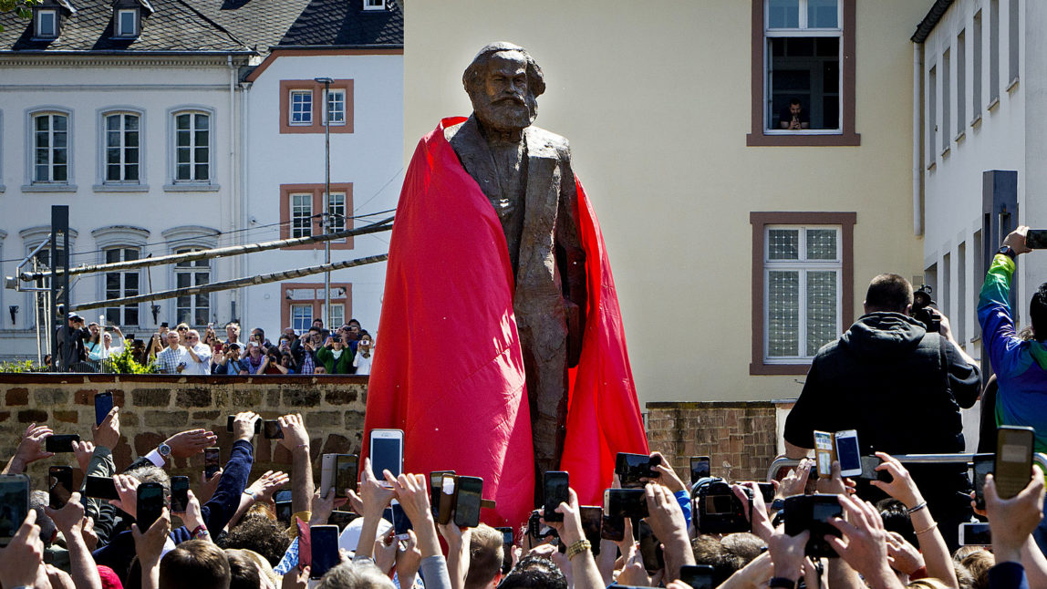 A bronze statue showing German philosopher Karl Marx is unveiled on occasion of the 200th birthday of Marx in Trier, Germany, Saturday, May 5, 2018. The statue was created by Chinese artist Wu Weishan and is a present of China. (AP Photo/Michael Probst)