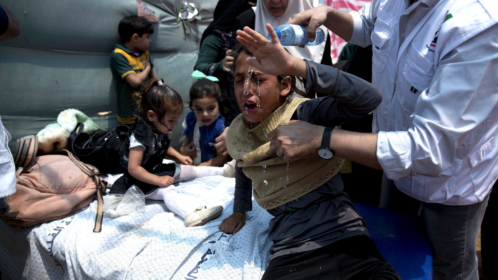 Medics treat Palestinian children suffering from teargas inhalation during a protest near Beit Lahiya, Gaza Strip, May 14, 2018. Israeli soldiers shot and killed dozens of Palestinians during mass protests along the Gaza border on Monday. It was the deadliest day there since a devastating 2014 cross-border war and cast a pall over Israel's festive inauguration of the new U.S. Embassy in contested Jerusalem. (AP/Dusan Vranic)