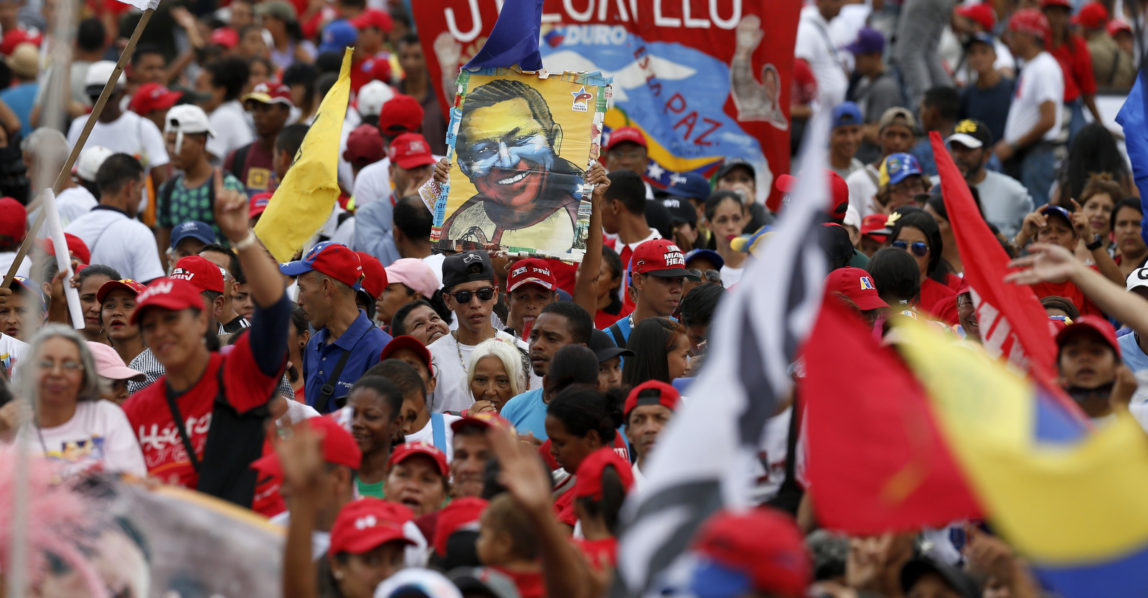 Supporters of Venezuela's President Nicolas Maduro hold a poster of late President Hugo Chavez during Maduro's closing campaign rally in Caracas, Venezuela, May 17, 2018. Ariana Cubillos | AP
