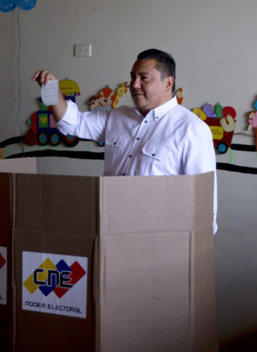 Opposition presidential candidate Javier Bertucci, a TV evangelist, shows his ballot during presidential elections in Valencia, Venezuela, Sunday, May 20, 2018. Amidst hyperinflation and shortages of food and medicine President Nicolas Maduro is seeking a second six-year term in an election that a growing chorus of foreign governments refuse to recognize after key opponents were barred from running. (AP Photo/Fernando Llano)