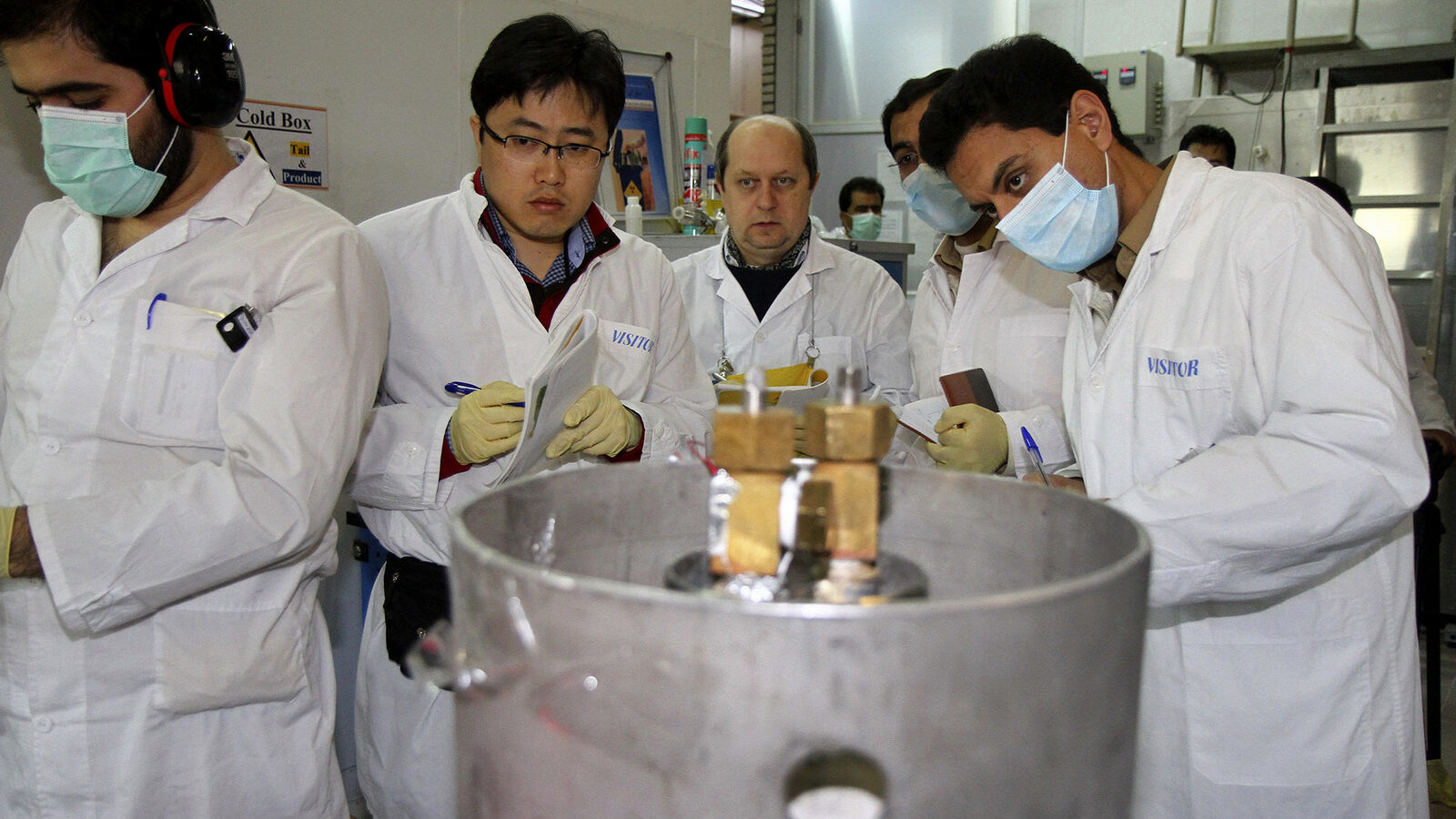 Unidentified International Atomic Energy Agency (IAEA) inspectors and Iranian technicians are on hand to cut the connections between the twin cascades for 20 percent uranium enrichment at Natanz facility, some 200 miles (322 kilometers) south of the capital Tehran, Iran, Monday, Jan. 20, 2014. Iran has halted its most sensitive uranium enrichment work as part of a landmark deal struck with world powers, state TV said Monday. The broadcast said Iran halted its 20 percent uranium enrichment, which is just steps away from bomb-making materials, by cutting the link feeding cascades enriching uranium in Natanz. (AP Photo/IRNA, Kazem Ghane)