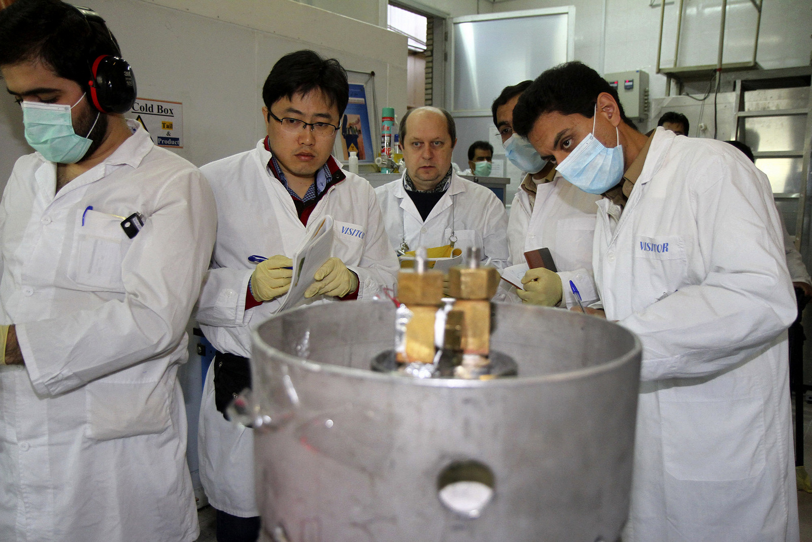 Unidentified International Atomic Energy Agency (IAEA) inspectors and Iranian technicians are on hand to cut the connections between the twin cascades for 20 percent uranium enrichment at Natanz facility, some 200 miles (322 kilometers) south of the capital Tehran, Iran, Monday, Jan. 20, 2014. Iran has halted its most sensitive uranium enrichment work as part of a landmark deal struck with world powers, state TV said Monday. The broadcast said Iran halted its 20 percent uranium enrichment, which is just steps away from bomb-making materials, by cutting the link feeding cascades enriching uranium in Natanz. (AP Photo/IRNA, Kazem Ghane)