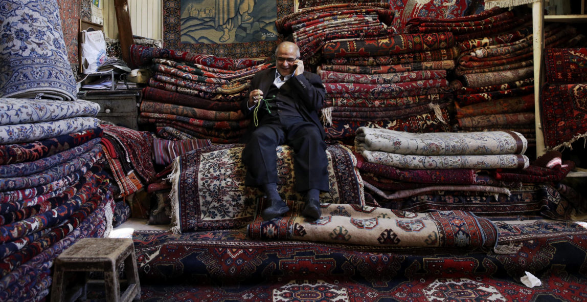An Iranian talks on his cellphone in a carpet shop at the old bazaar in Tehran, Iran. Vahid Salemi | AP