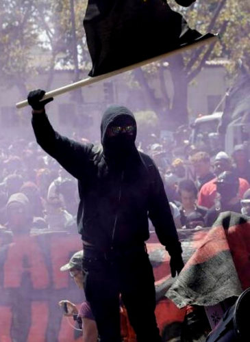 An anti-fascist demonstrator jumps over a barricade during a free speech rally Aug. 27 in Berkeley, Calif. (AP Photo)