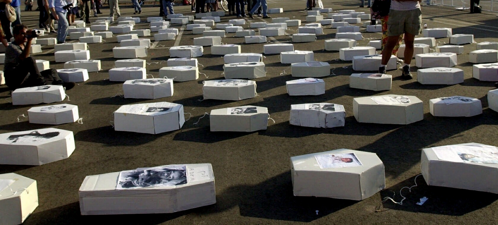 Makeshift coffins bearing the photos of Iraqi children are arranged in the designated protest area outside of the Democratic National Convention in Los Angeles, Aug. 15, 2000. U.S. sanctions killed hundreds of Iraqis each day. Nick Ut | AP