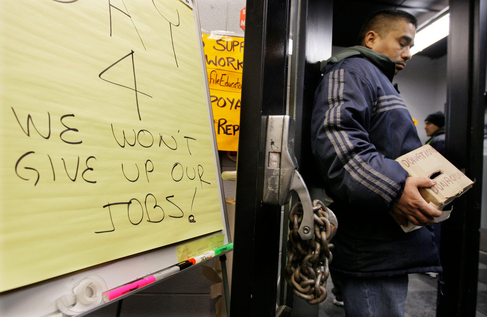 Fielipe Dillado, a ten year employee, holds a donation box on the fourth day of a sit-in at the Republic Windows and Doors factory, Dec. 8, 2008 in Chicago. M. Spencer Green | AP