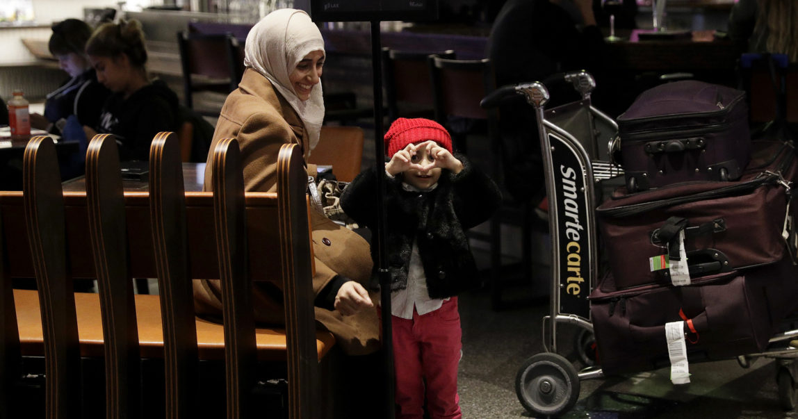 Standing next to her mother, Samar Alwahiri, 3-year-old Laila Alamri, of Yemen, tries to make a heart shape with her fingers at Los Angeles International Airport, Feb. 8, 2017, in Los Angeles. Donald Trump's travel ban left Yemenis stranded in and elsewhere. Jae C. Hong | AP