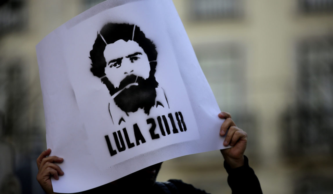 A protestor holds up a poster with a picture of Brazil's former President Luiz Inacio Lula da Silva during a demonstration in his support in Lisbon, Monday, April 9, 2018. Lula da Silva was taken into police custody Saturday, April 7, after the Brazilian Supreme Federal Tribunal ruled against his petition to remain free while he continued to appeal his 12-year sentence for money laundering and corruption. (AP Photo/Armando Franca)