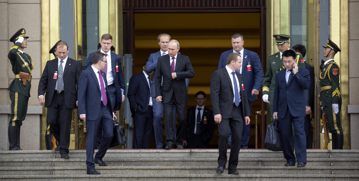 Russian President Vladimir Putin, center, leaves the Great Hall of the People after meeting with Chinese Premier Li Keqiang in Beijing, Friday, June 8, 2018. Putin is in China to attend the Shanghai Cooperation Organization (SCO) Summit in Qingdao. (AP Photo/Mark Schiefelbein)