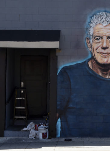 Food writer Hadley Tomicki, of Los Angeles, is accompanied by his daughter Kira, 1, as he takes a picture of a new mural of the late chef/writer/television personality Anthony Bourdain, created by artist Jonas Never, June 18, 2018, on a side wall of the new restaurant Gramercy in Santa Monica, Calif. Bourdain died Friday, June 8, in France in an apparent suicide. Chris Pizzello | Invision | AP)