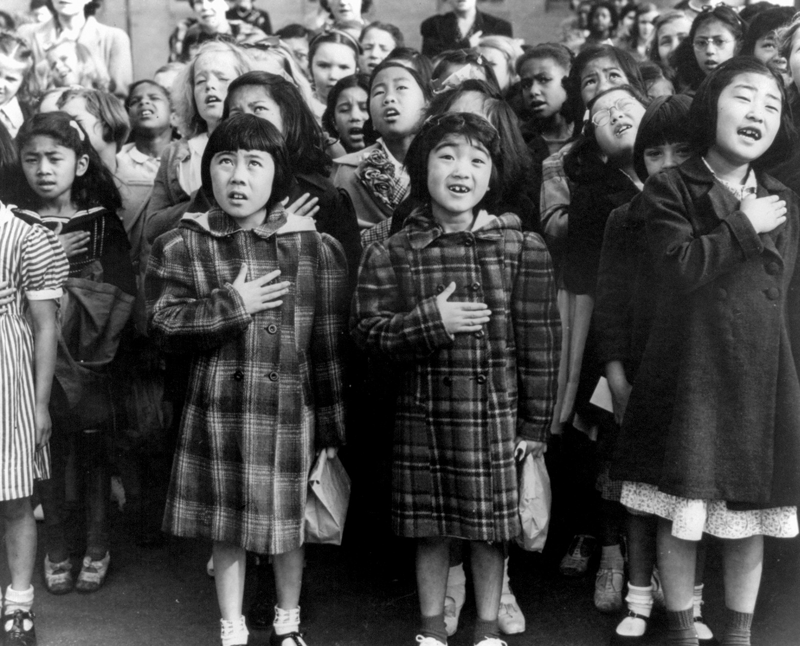 旧金山威尔公立学校的孩子们背诵忠诚誓言。其中一些人是日本血统的撤离人员，他们将在1942年4月的第二次世界大战期间被安置在战争重新安置局的中心。Dorothea Lange |美国战争安置局通过美联社