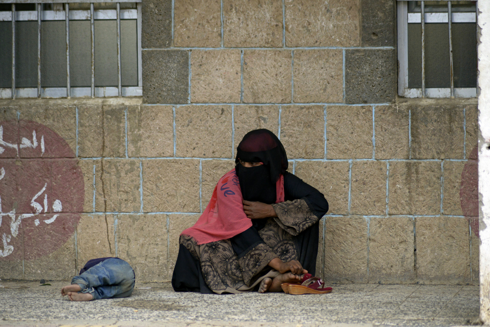 2018年6月23日，也门的一位母亲和她的孩子被沙特阿拉伯联合酋长国的一次致命袭击流离失所，他们坐在也门萨那的一所分配给国内流离失所者的学校里。哈尼·穆罕默德|美联社